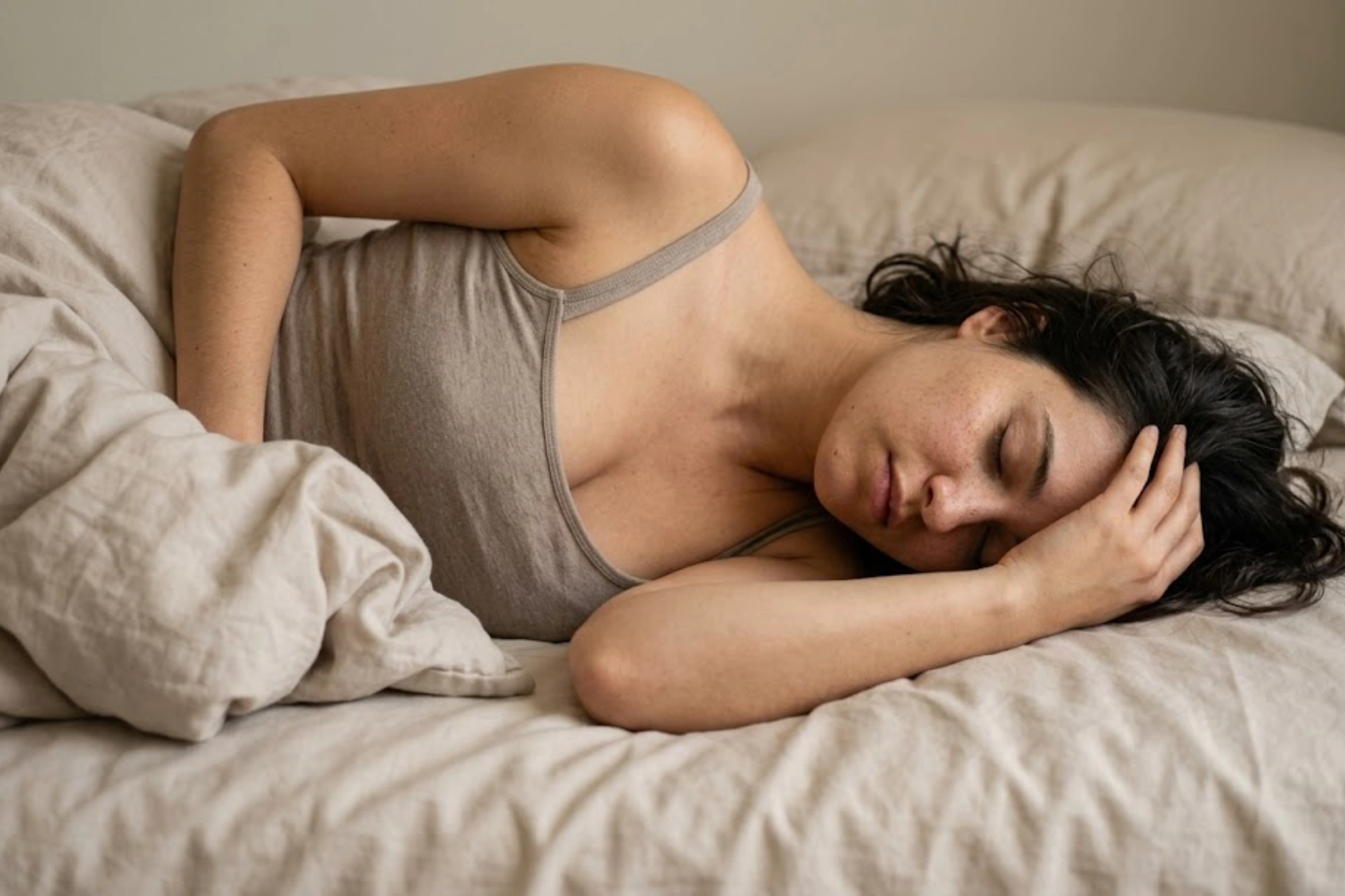 Head folded forward into a flat pillow at night